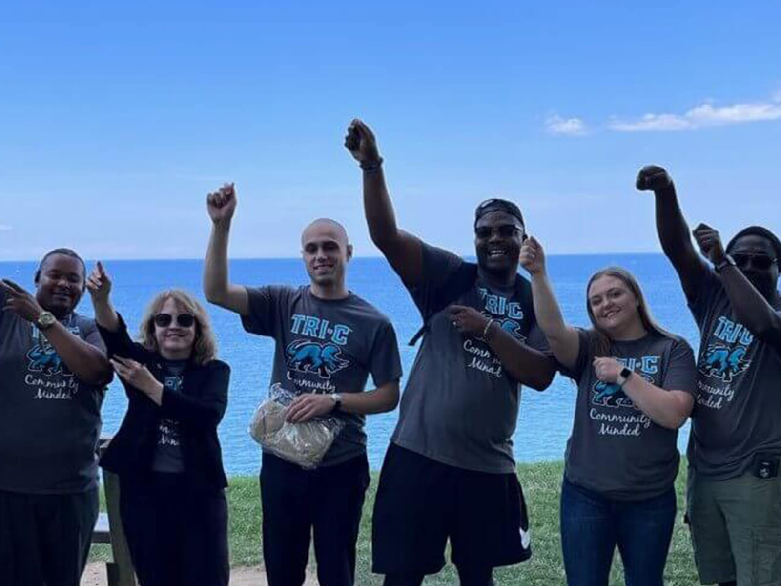 A collective of people proudly displaying "be the change" t-shirts, symbolizing unity and a commitment to making a difference.